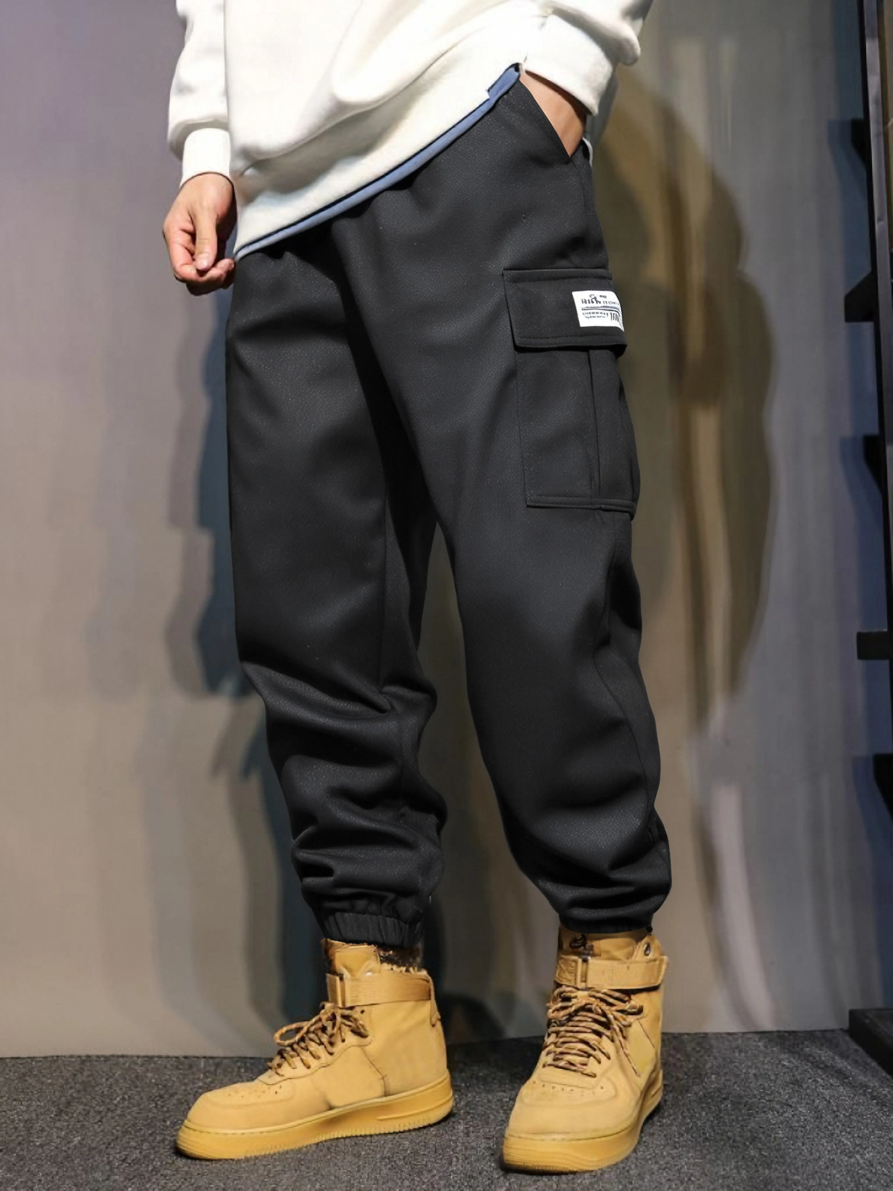 Men’s loose cargo jogger pants with multiple pockets and a drawstring waist, featuring an elastic waistband and elastic cuffs; street-style long pants suitable for everyday wear. If you prefer a looser fit, we recommend ordering one size up.
