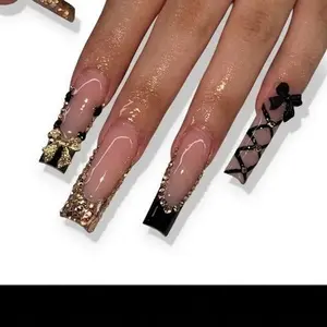 Elegant Black and Gold Nail Art with Bow and Rhinestones for a Chic Look