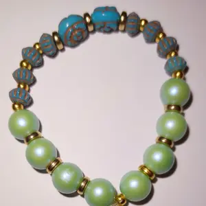 Verdant Whimsy Bracelet - Handcrafted with Pearlescent Green Beads, Blue Accents, & Dangling Floral Charm - 7-7.5 Inches Long for Adult Wrist