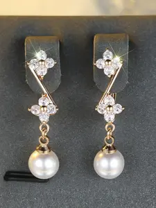 A pair of round white diamond and pearl tassel earrings, featuring synthetic crystals, exuding a sense of fashion and elegance. Perfect for weddings and daily wear as a piece of women's jewelry.