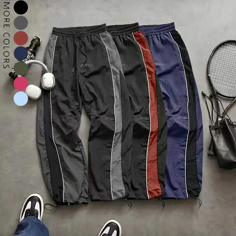 Men’s high street style wide leg pants with contrast color panels, side stripes, and a drawstring; American retro loose, drapey athletic pants; available in multiple colors; slim casual pants suitable for spring and summer wear.