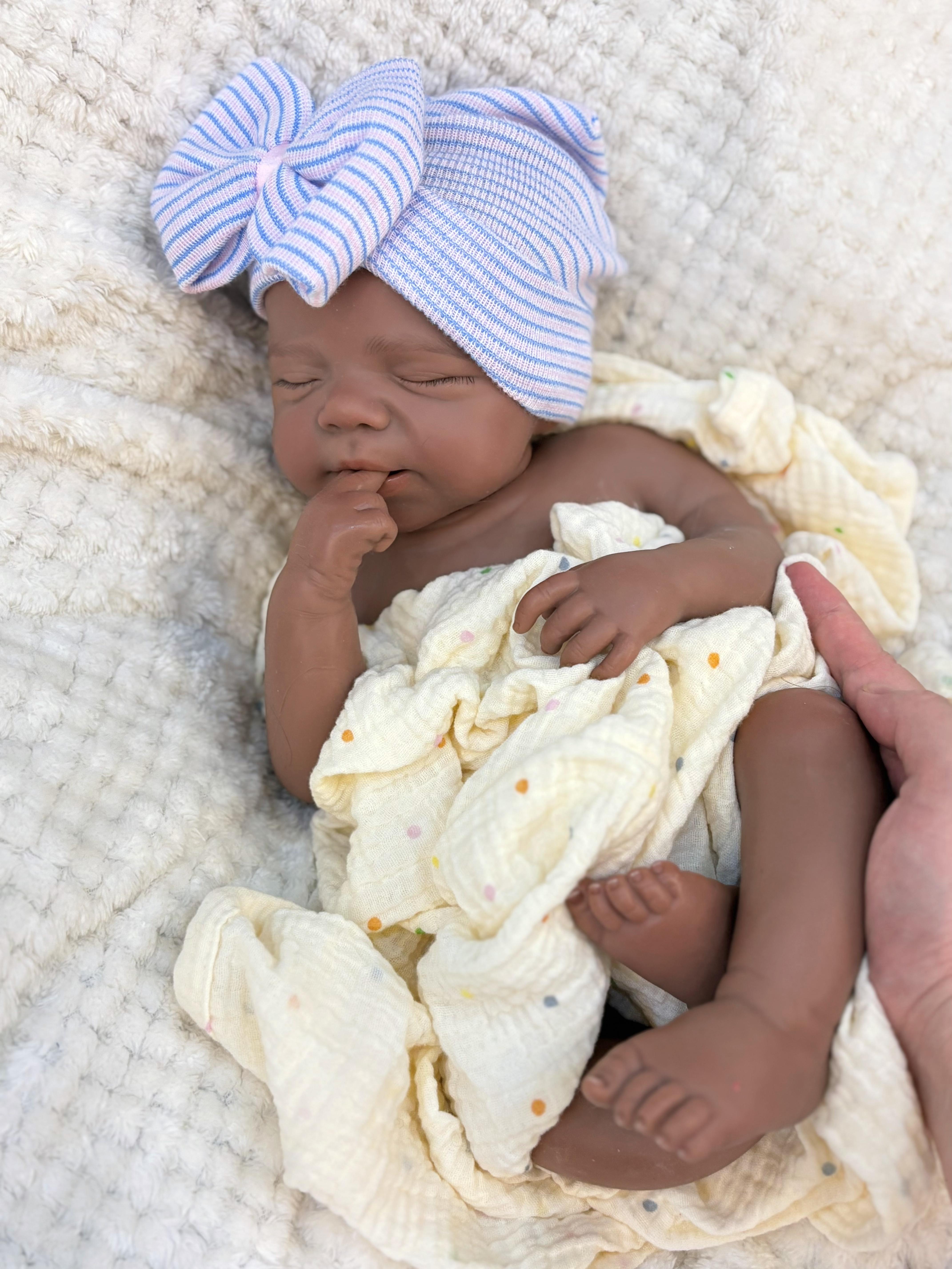 Reborn doll, soft silicone — 18 inches tall, lifelike with closed eyes for sleeping, brown skin, a soft body, and realistic detailed features. Includes a comfort item, a bottle, and a birth certificate. Perfect for birthday gifts, collectors, and children