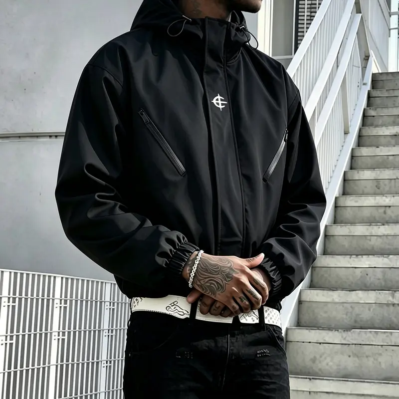 Men’s functional outdoor windproof hooded jacket featuring diagonal waterproof zippered pockets, a drawstring hood, and elastic cuffs; lightweight waterproof zip-up outerwear suitable for everyday commuting and hip-hop street styles.