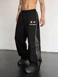 Men’s high-street style sweatpants with color-block panels and side stripes, tapered wide-leg or straight-leg cut, American retro cartoon print design, relaxed drape, available in multiple colors, lightweight casual pants for spring/summer.