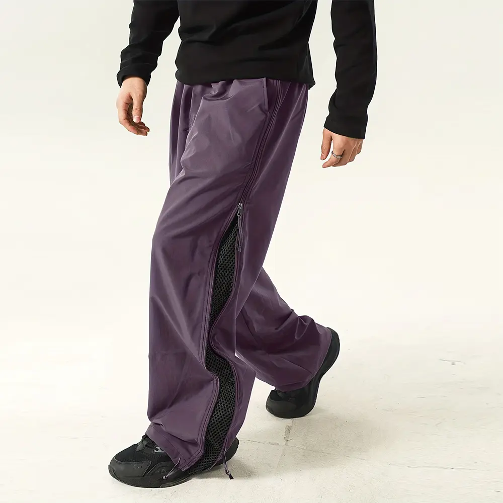 Men’s casual athletic long pants featuring a side full-length zipper and mesh panels, a loose fit, elastic waistband with drawstring, and cuffed ankles. Polyester fabric is lightweight and thin, selected for everyday wear.