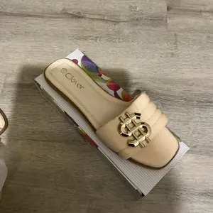 Women's Footwear - Elegant Beige Slippers with Gold Logo Detailing for Comfortable Wear