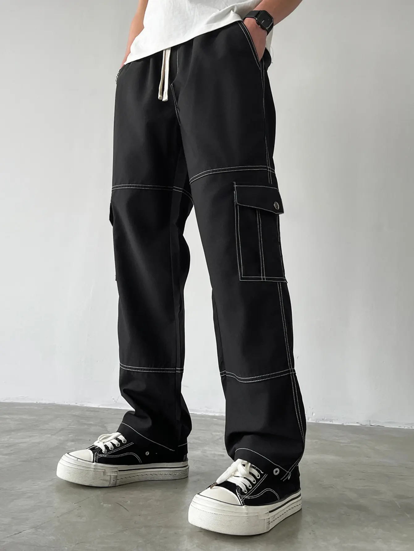 Unisex cargo pants with contrast topstitching, multiple pockets, relaxed straight leg — elastic drawstring waist, flap cargo pockets, 3D panel stitching, drapey wrinkle resistant woven fabric, black & white, American high street casual trousers for skatin