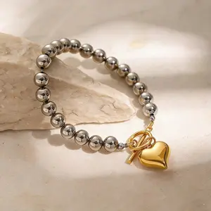 The "Color-Block Heart" Necklace features a striking contrast between its long silver beaded chain and a gold-tone toggle clasp and heart pendant—creating a versatile accessory perfect for achieving a layered look.