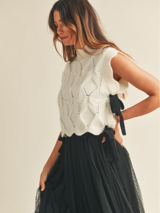 Wishlist Vest - White comfy cable knit sweater vest with scallop details, black side bows, and a turtleneck, offering a slightly oversized fit