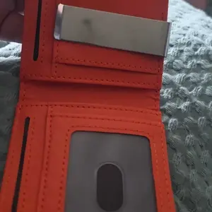 This men's ultra-thin carbon fiber textured bi-fold card holder features an RFID-shielded banknote clip and multiple card slots, making it safe, practical, and suitable for everyday use.