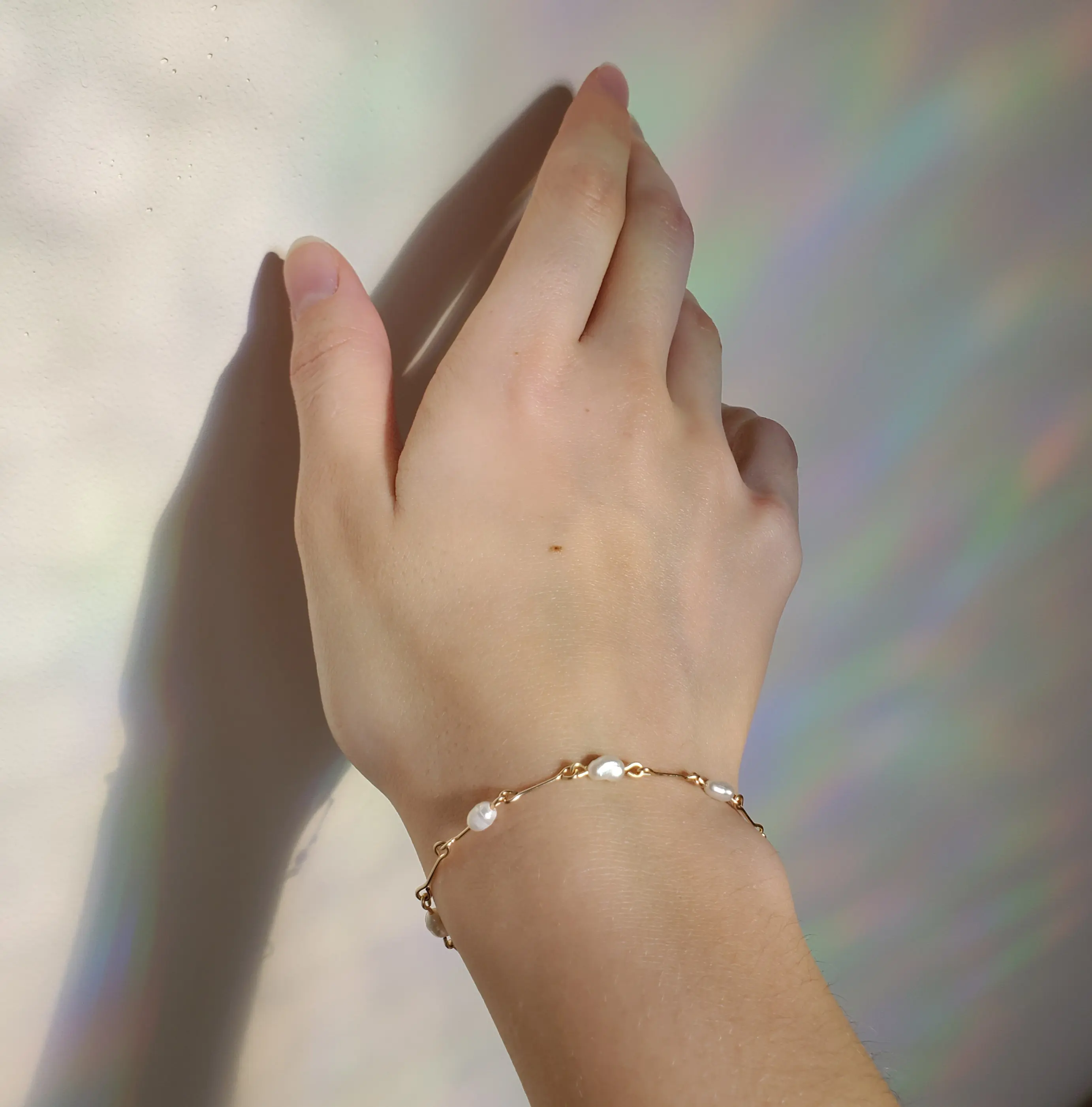 Limited edition delicate thin golden wire bracelet with white beads, delivered in 100% compostable package