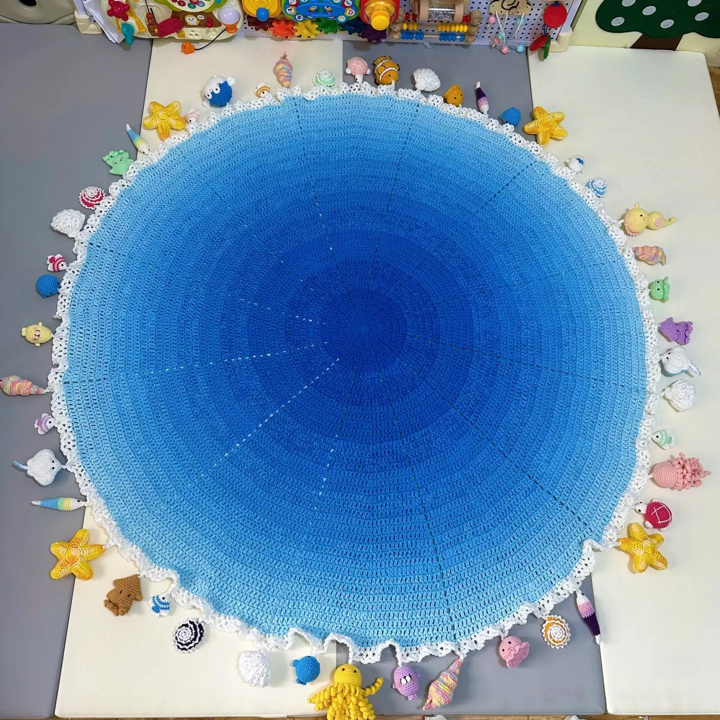 Ocean-themed blanket, hand-crocheted with a gradient color scheme (size and number of embellishments can be customized). Now available for pre-order.
