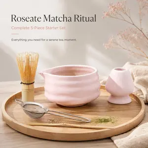 The complete five-piece beginner set includes a pink ceramic matcha bowl with a bamboo whisk, tea spoon, whisk stand, and matcha powder sieve for traditional matcha brewing.