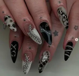 Edgy black and white gothic nails with smoky patterns, chains, metallic bones, and bold 3D accents, perfect for a dark, fierce, and statement-making style