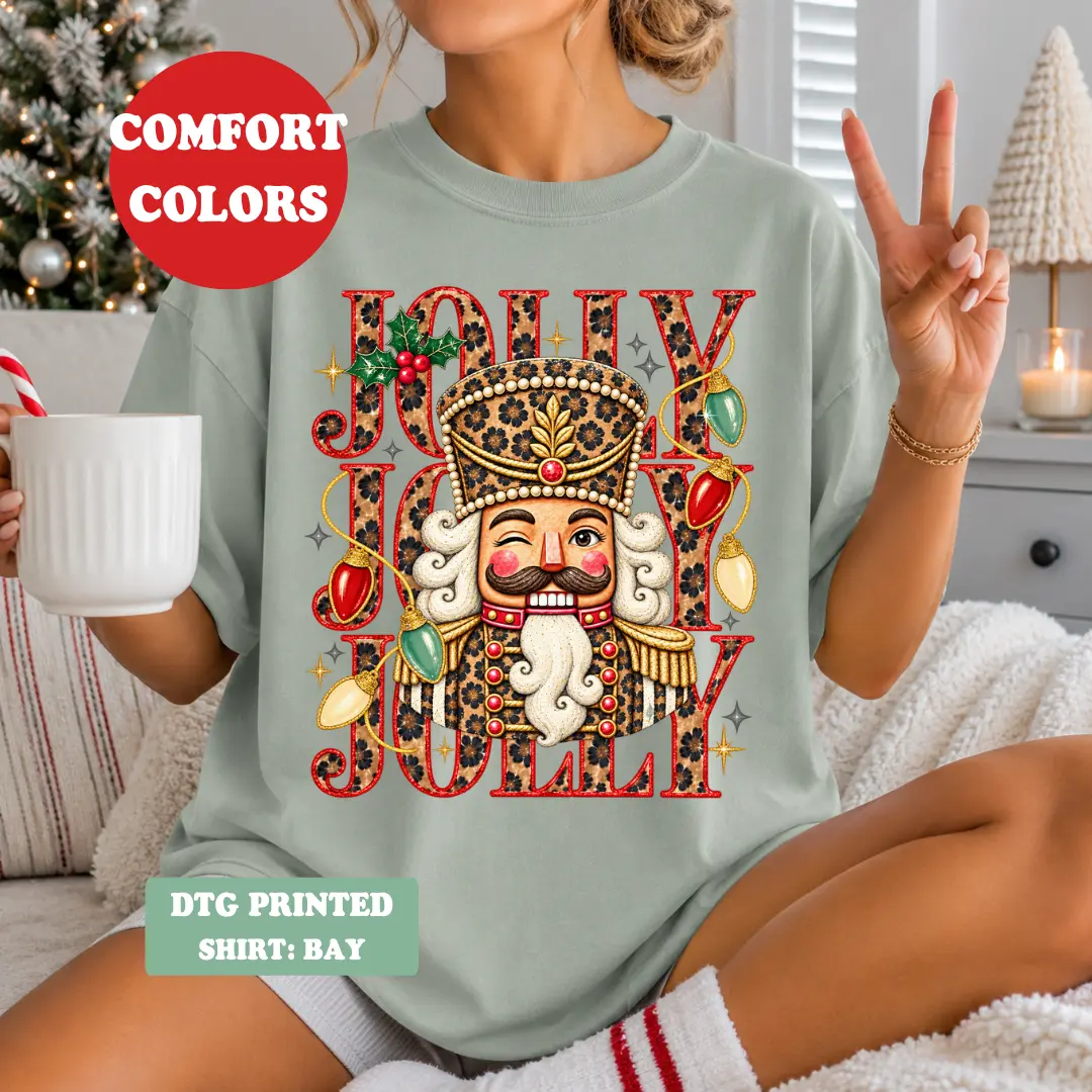 Jolly Nutcracker Christmas Graphic T-Shirt for Women | Leopard Print Nutcracker Comfort Colors Tee | Vintage Christmas Nutcracker Shirt | Trendy Holiday Christmas Lights Graphic Tee | Festive Retro DTG Printed Shirt