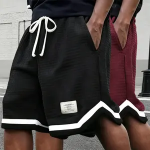 Two men’s casual shorts featuring a waffle texture with contrasting piping; urban relaxed style. White drawstring waistband paired with contrast piping; waffle texture fabric body with square fabric tag enhances textural details. Soft, drapey, comfortable