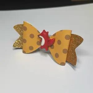 Ruby Bowtique yellow polkadot and gold glitter faux leather hair bow with cute animal charms