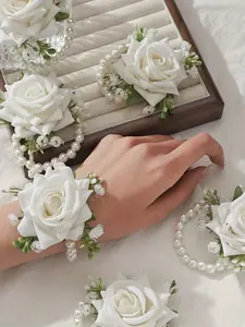 A wrist corsage with 4 to 6 elegant white roses, paired with white baby's breath and faux pearl chains, adorned with beautiful green leaves, durable and comfortable to wear, making it the perfect bridal wedding accessory for brides and guests.