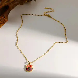 Collar con colgante, de acero inoxidable 304 con baño electrolítico de oro y acabado acuático, con cadena tipo «Lip».