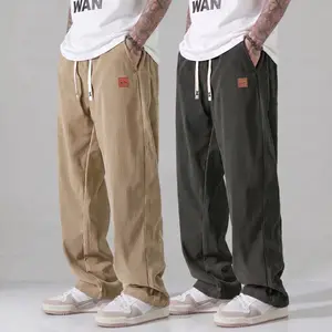 Men’s drapey corduroy pants for summer, leather tag detail, drawstring elastic waistband, loose straight wide-leg fit, conceals curves, elongates legs, versatile men’s trousers