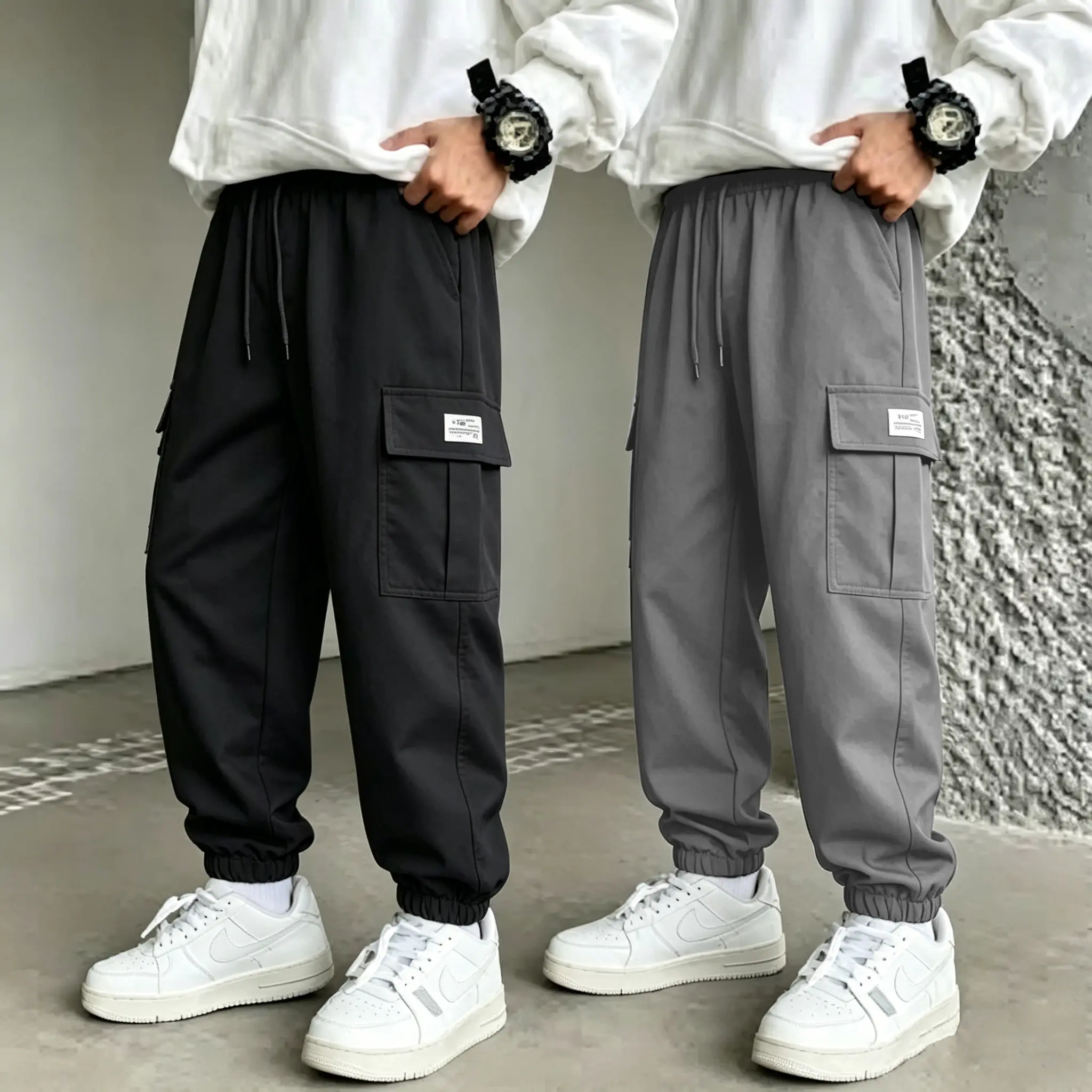 2-pack men’s elastic-waist cargo jogger pants featuring a drawstring waistband, multi-purpose pockets, cuffed legs, and side label decoration. It belongs to a casual street-style design and can also be used as hiking pants for outdoor activities; it’s typ