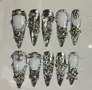 Fierce metallic silver nails with bold 3D embellishments and intricate gothic details, creating a dramatic and high-fashion statement look