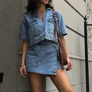 Women’s two-piece denim outfit featuring a short-sleeved denim top with a lapel collar and asymmetrical shorts—streetwear by GARMENTARY