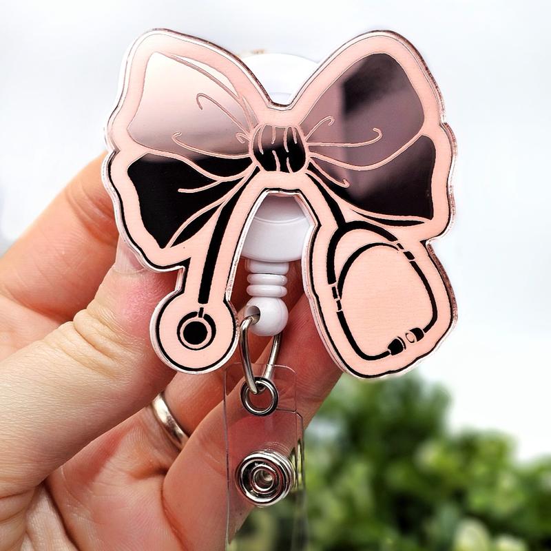Bow with Stethoscope Badge Reel, Laser Engraved with Smooth Mirror Finish, Funny Badge reel for nurses, xray techs and hospital workers. Retractable swivel clip with a 360 rotation. Great gift for coworker. Cute Badge for Work. Badge clip, Badge pull