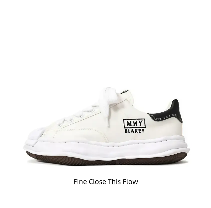 Polished cream white leather low-top shell-toe trainers with thick fluffy white laces, crumpled undulated white cushion platform sole and grippy dark gum traction outsole, perfect for street fits, jeans and vintage casual fashion looks.