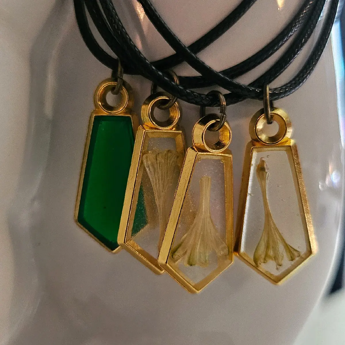 Small gem shaped resin necklaces with Spotted Dracaena flower