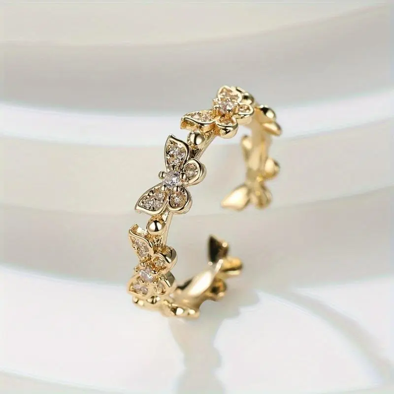 A stylish and unique copper ring for women, featuring zirconia stones in a butterfly design, adjustable and open-ended