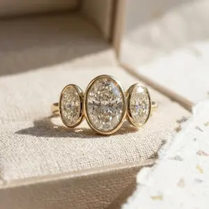 RIQUINNI Three Stone Oval Cut Moissanite Engagement Ring, D Color VVS1, Gold Plated Sterling Silver, Bezel Set, Sizes 4-12