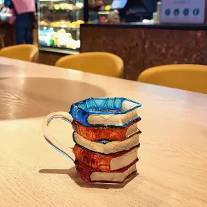 Innovative Hand-Painted Ceramic Book Mug — A Unique Stacked-Book-Shaped Coffee Cup. The perfect gift for literature enthusiasts, featuring a creative and colorful book design—an ideal choice for Christmas. Reusable.