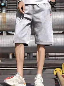 Men's sports-style elastic waist shorts with a regular fit, featuring zippered side pockets and an adjustable waistband. A small red tag on the pocket adds a special touch, offering a comfortable fit for casual, sports, and outdoor activities.