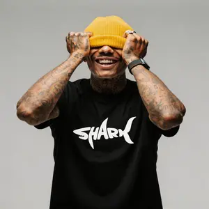 Minimal shark-themed T-shirt with styled text print; plain solid color base; breathable lightweight cotton; casual everyday wear; unisex short sleeves; crew neck top; simple marine theme fashion outfit; suitable for all seasons; two color options.