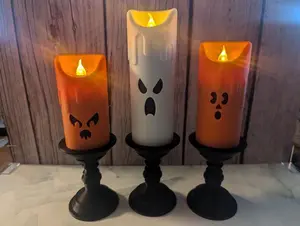 Three eerie Halloween LED candles with ghostly faces that are 3D printed