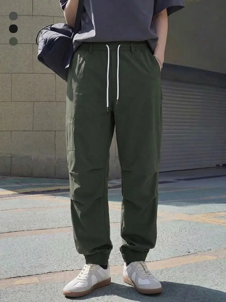 Men’s cargo jogger pants for spring/summer, featuring a functional multi-pocket design, contrasting white accents and drawstring, ribbed cuffs, and a loose, slightly wide fit—ideal for city outings, short trips, and everyday streetwear.