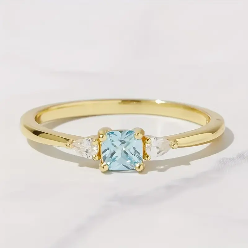 A minimalist, affordable luxury ring featuring three stones; a unique ring with synthetic aquamarine and zirconia; classic cushion cut; an exquisite, niche design in the affordable luxury style; perfect for everyday wear; an ideal anniversary gift for her