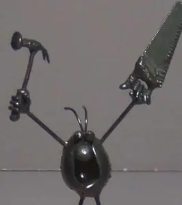 Handmade metal sculpture of a carpenter holding tools