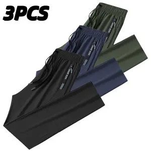 Set of three solid-color men’s straight-leg casual pants with side branding; urban relaxed style. Elastic waistband with black drawstring for adjustable fit. Ice silk fabric is smooth and drapes with a cooling feel; loose straight cut that flatters leg sh