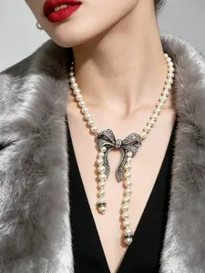 A vintage necklace, Classic statement necklace, with a beige pearl chain paired with an antique silver full diamond bow pendant, exuding a light and mature socialite temperament, suitable for dates, dinners, and light social occasions