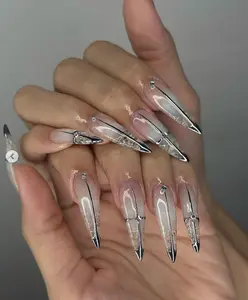 Edgy stiletto nails with a sleek ombré nude base, sharp chrome silver tips, and metallic accents for a bold futuristic high-fashion vibe