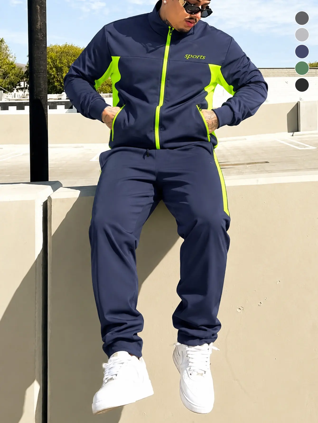 Men’s two-piece athletic set featuring navy blue and fluorescent green, including a full-zip jacket and jogger sweatpants. Stylish menswear available in multiple colors, suitable for all seasons.