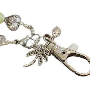 Phone wristlet lanyard with 4mm silver beads and rhinestone charms plus a silver lobster claw closure. Attached to phone with plastic tab that goes under the phone cover included TPU
