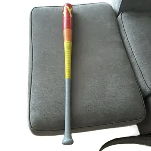 Wiffleball Bats and Balls - Colorful Bat with Yellow and Orange Design on Gray Couch