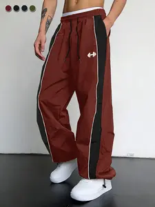 Men’s burgundy color-block athletic pants featuring an elastic drawstring waist, a loose fit, breathable fabric, side stripes, and dumbbell print design—suitable for spring and summer streetwear, everyday wear, and gym workouts.