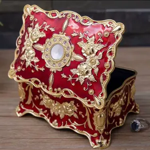 Red and Gold Metal Jewelry Box with Elegant Floral Design and Gemstone Accent