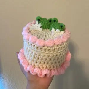 Crochet Cake Box with Green Frog Decoration and Pink Trim Detailing
