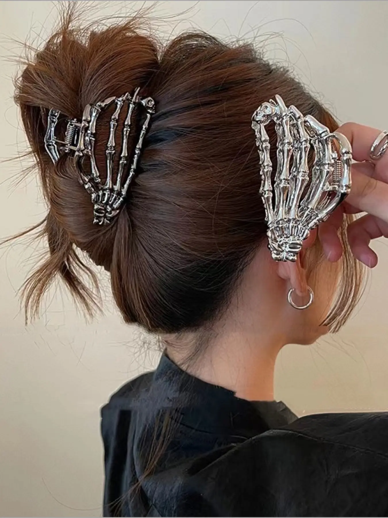 A skull Hair Claw Clip in the shape of a skull hand. A sturdy metal structure that tightly grips the hair. Avant garde Gothic style, suitable for festivals, daily dressing up, and Halloween. A cool gift for alternative fashion enthusiasts! Hair Clips