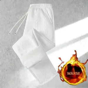 A pair of white textured drawstring men's fleece pants, an 가을 필수 item, featuring a simple high end style with a white main tone that exudes clean sophistication. The textured design and drawstring details add a tactile element, while the loose and comfort
